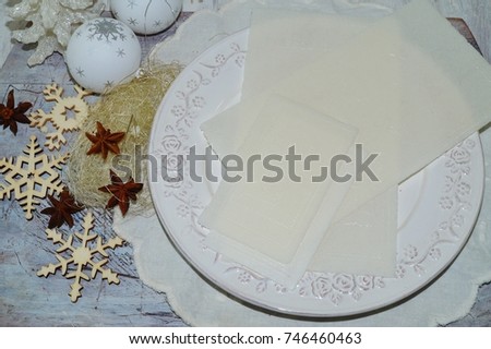 Traditional Christmas wafer on a wooden table on a white plate
