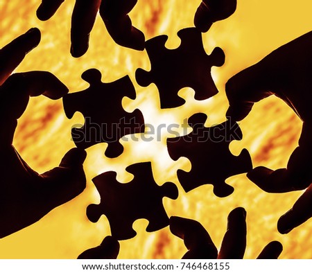 four hands trying to connect 4 puzzle piece with sunset background. Jigsaw alone wooden puzzle against sun rays. four part of whole. symbol of association and connection. business strategy.