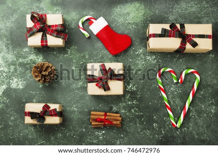 Boxes with gifts for Christmas and various attributes of holiday on a green background. Top view
