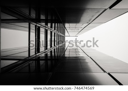 Abstract image of looking up at modern glass building. Architectural exterior detail of industrial office building. Industrial art and detail.