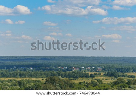 the view from the hill on summer rural landscape. forests and meadows to the horizon