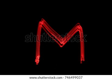 Letter m, capital letter, red light painting photography, long exposure, against a black background