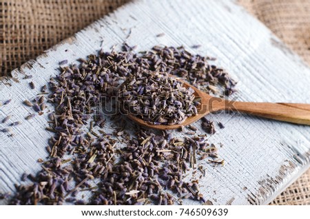 Spilled dry lavender in a wooden spoon on a rustic wooden tray. Preparing for cooking. Close up view Royalty-Free Stock Photo #746509639
