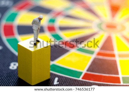 miniature business people standing on wooden box with  dartboard. Thinking, Target business concept.