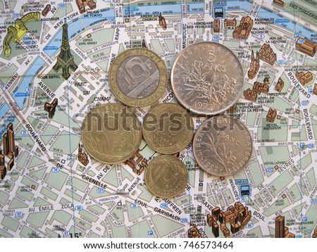 Paris theme. Symbols of France in flat layout or background. Old French coins francs and centimes on map of Paris. Vacation tour or tourist journey to Europe
