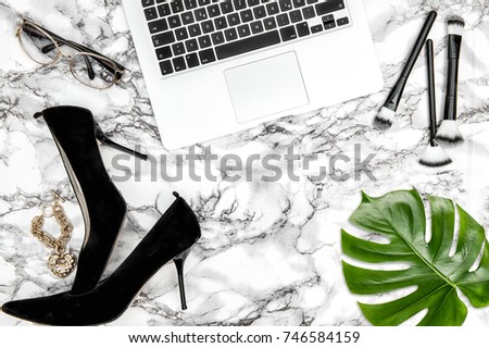 Feminine accessories, notebook, shoes, green monstera leaf on table background. Fashion flat lay for social media