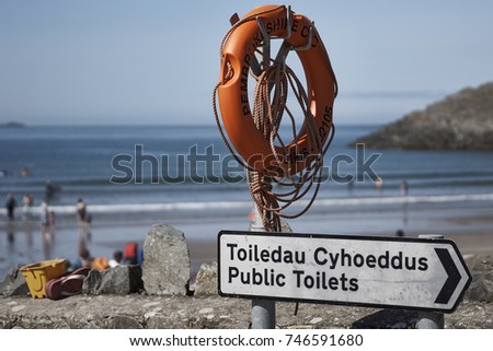Street sign at the beach for 'Toiledau Cyhoeddus' - public toilet sign in Welsh - Whitesands Bay, Pembrokeshire, Wales