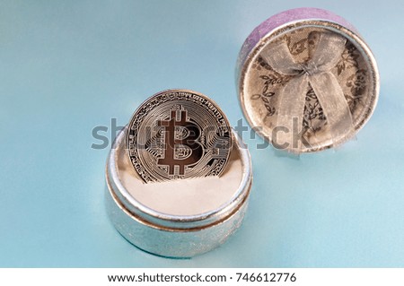 Coin bitcoin in a gift box for a ring or jewelry. The concept of crypto currency. The best gift for the holiday. A gift in Christmas. On blue background.