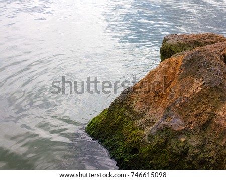 Stones are covered with green moss in lake in background. Authentic landscape.