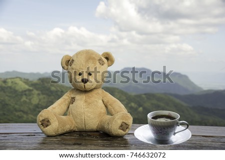 Teddy Bear sitting on a wooden floor with morning coffee