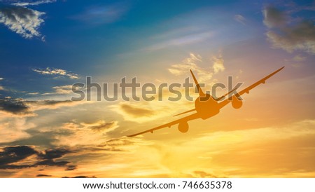 Silhouette from a landing plane that is flying to the airport. Photo taken during a nice colorful sunset.