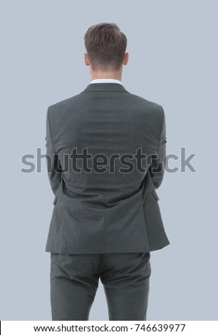 Businessman from the back - looking at something over a gray bac