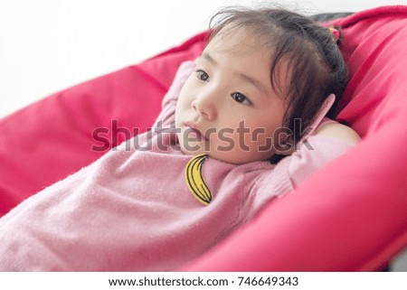 Happy little girl looking at cartoon on the couch