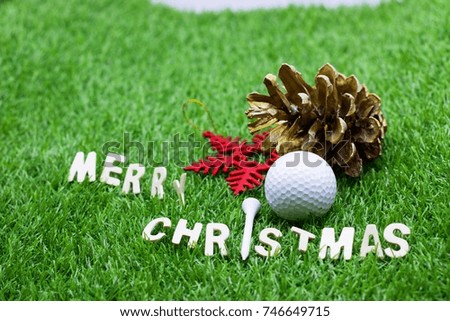 Merry Christmas to golfer with golf ball and pine cone on green grass