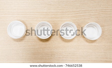 white plastic bottle cap on wood background