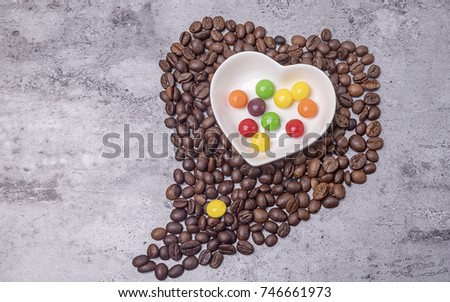 The heart-shaped coffee beans and the rainbow sugar in the dish