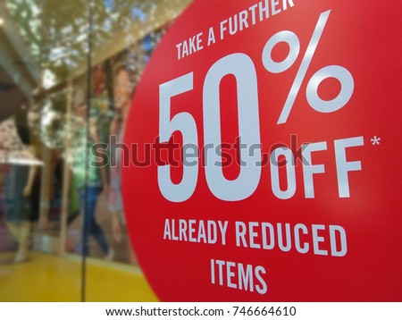 Large Sale 50% off letters on a glass wall obstruct a view inside the popular clothing store