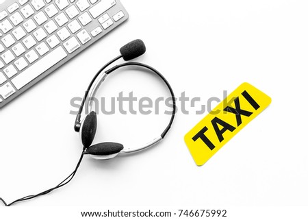 Taxi service online. Taxi label, keyboard, headphones on white background top view