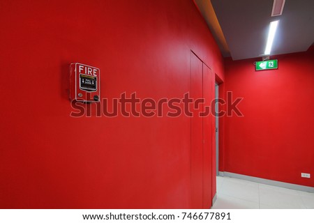 Emergency exit of the building with fire exit sign and fire alarm