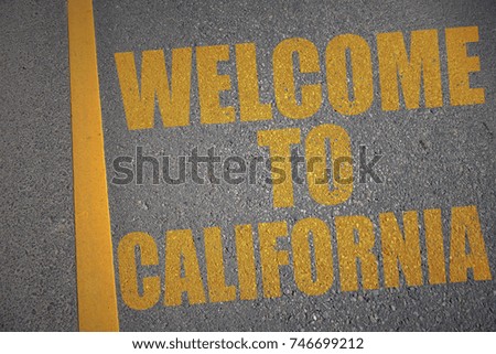asphalt road with text welcome to california near yellow line. concept
