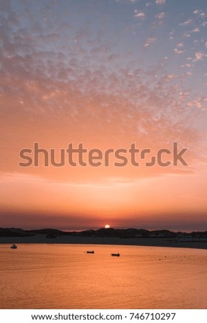 Sunset on the Atlantic Ocean. Boats in the bay on the batch. Long exposure.Portugal. Portuguese.Villa Nova de Milfontes
