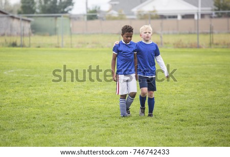 Soccer teammates consoling each other after a tough loss on a soccer field. Concept photo of encouragement from friends after disappointment from a loss Royalty-Free Stock Photo #746742433