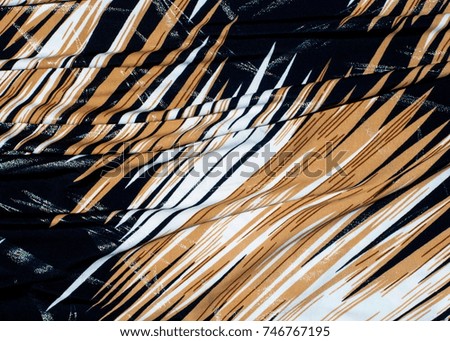 texture of silk fabric. background. Yellow brown white stripes line. On a black background. Brilliant line.