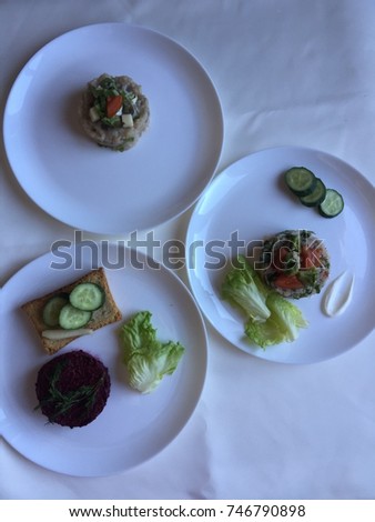 Salad leaves, toast and slices of cucumber with beet salad roll on a white background.