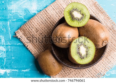 Kiwi fruit in a bowl on wooden background.  With copy space