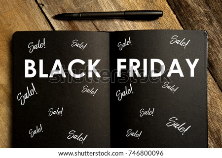 Top view of notebook written with BLACK FRIDAY and sale with pen on wooden background. Flat lay.