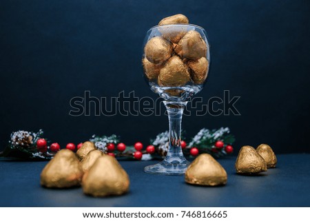 New year Gold Candy in a glass on dark blue background