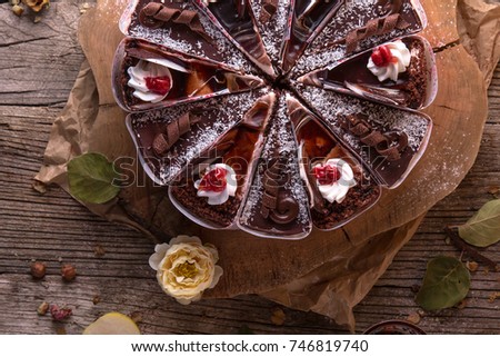 Chocolate cake with nuts, cut into slices on a rustic background. View from above. Free space for text.