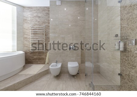 Brand new bathroom interior design. Luxury modern bathroom with white bath tub, washing machine, walk in shower with glass door. Royalty-Free Stock Photo #746844160