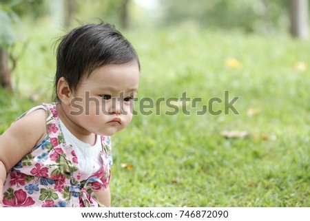 Cute little asian baby looking someting in the park 