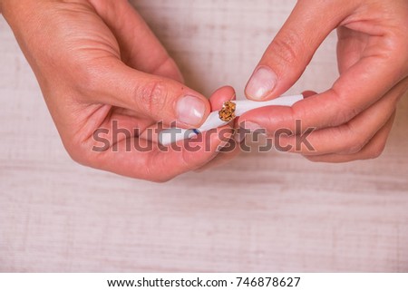 image of a crushed cigarette butt in female hands is quit smoking concept.Good for  Great American Smoke out Day in November or any lung cancer issue.No Smoking Campaign.in May World No Tobacco Day.