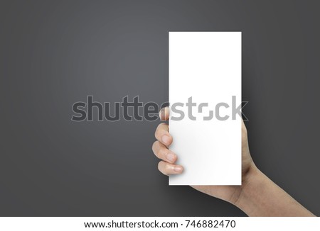 Woman hand holding a blank brochure booklet mock up on a black background. Royalty-Free Stock Photo #746882470