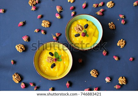 Mango  cream bowls, top view, blue background.
