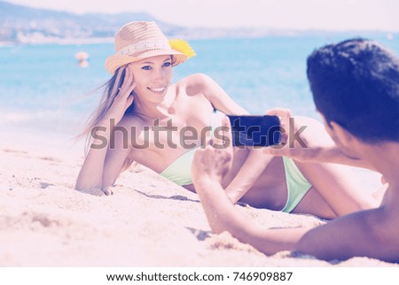 young couple relaxing on beach taking selfie picture with camera smartphone
 