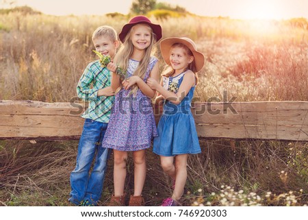 Kids having fun and happy time over sunset at countryside