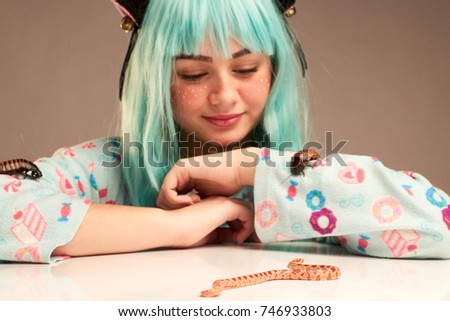 Portrait of a girl in cartoon style with blue hair and cat's ears with a snake and madagascar cockroach