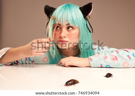 Portrait of a girl in cartoon style with blue hair and cat's ears with a snake and madagascar cockroach