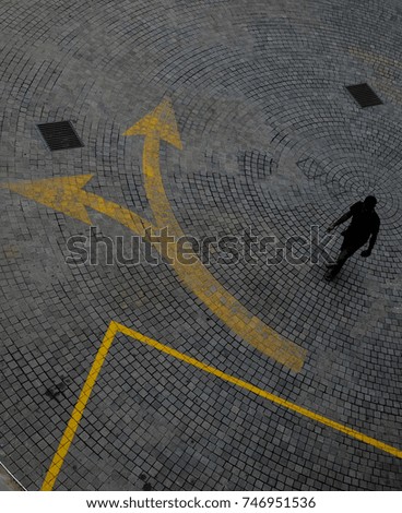 Yellow direction sign on a pavement 