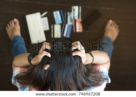Top view of stressed young asian woman trying to find money to pay credit card debt. Royalty-Free Stock Photo #746967208