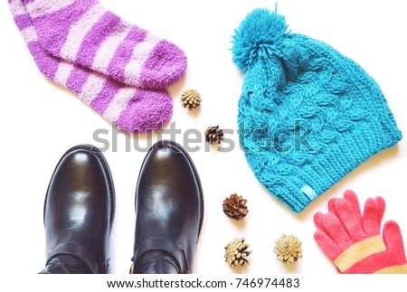 Clothes stuff. Purple socks, leather boots, pine cones, blue woolen knitted hat and pink gloves. Fall fashion. Autumn and winter women's clothes. Flat lay stock photography for fashion blog