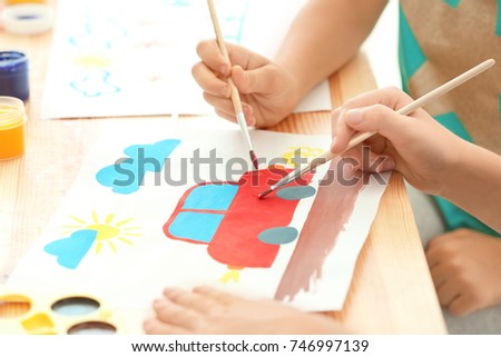 Cute children painting at table indoors