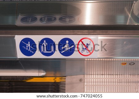 signs on an escalator, warning signs, the escalator at the air port