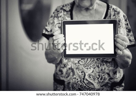 elder woman holding tablet