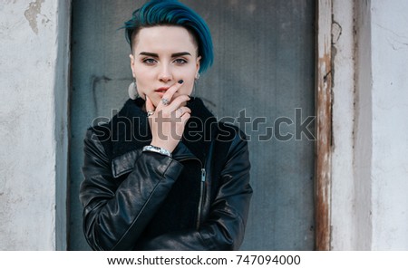 Lonely girl with blue hair. Face and hands. Standing in front of the door.