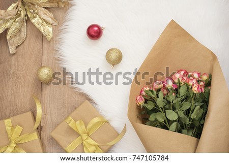 Large luxury bouquet of roses, Christmas balls and gifts on a fur carpet. Winter holidays concept