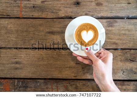 hands holding coffee cup,heart on coffee cup and woman nails,valentine love concept.